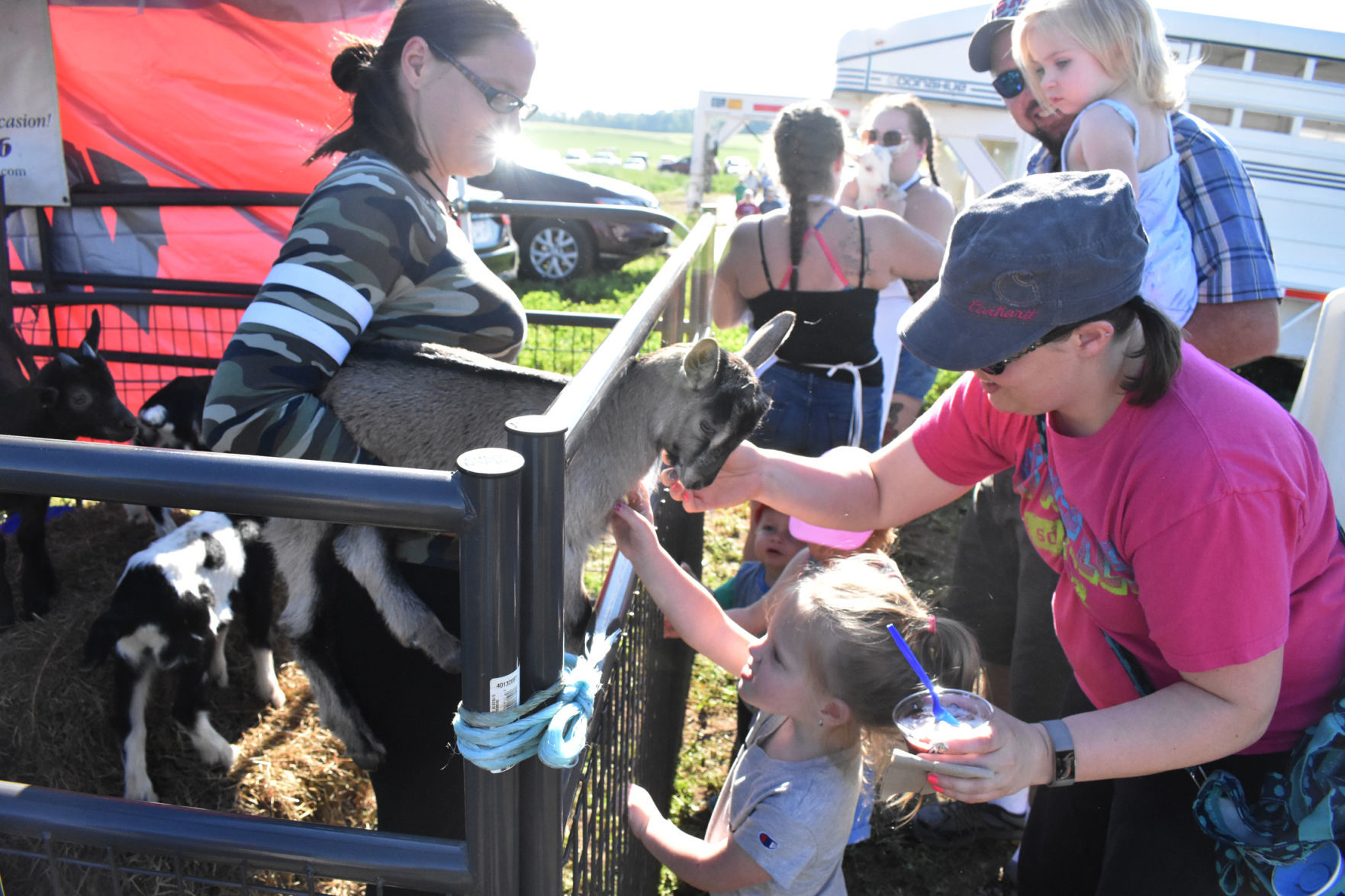 Mom and daughter petting goats